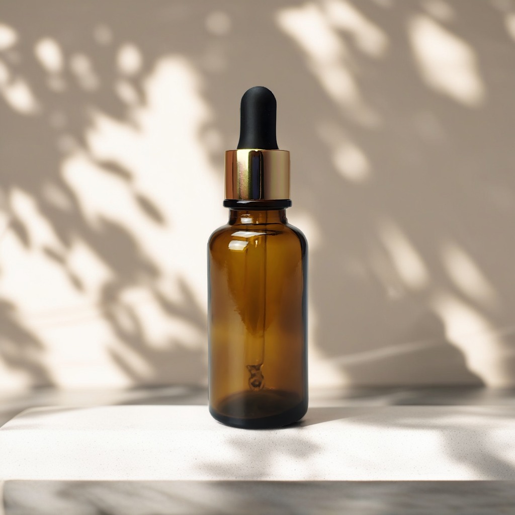 30 ml brun glasflaske med guld pipettelåg placeret på lys sandstensoverflade i diffust dagslys